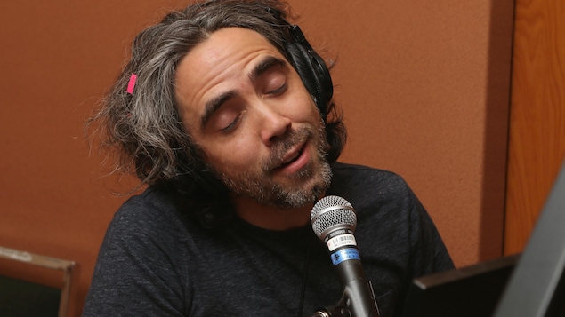 Photo de Patrick Watson, les yeux fermés, qui joue au piano et chante dans un micro.
