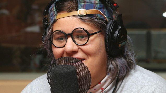 Photo de Safia Nolin devant un micro de radio.