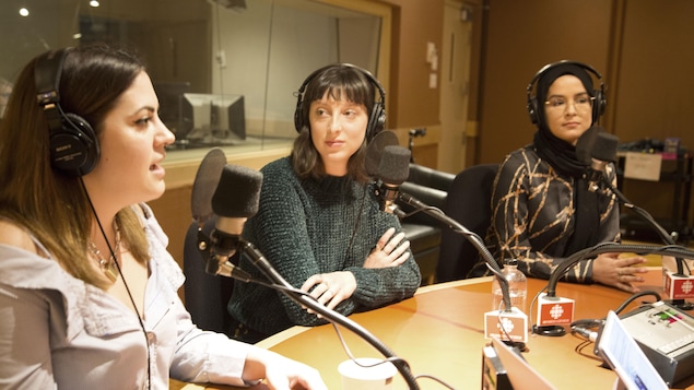 Les trois femmes sont assises à une table ronde sur laquelle est posée des micros.