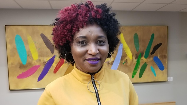 Elle est debout devant une toile dans l'édifice de Radio-Canada à Regina.