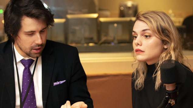 Un homme consulte un texte, une femme regarde devant elle.