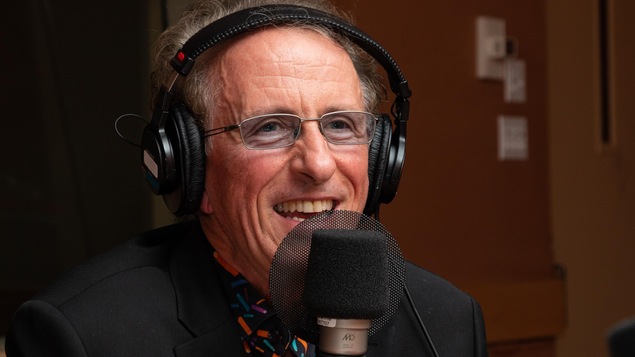Le musicien aux lunettes bleutées sourit à l'animatrice.