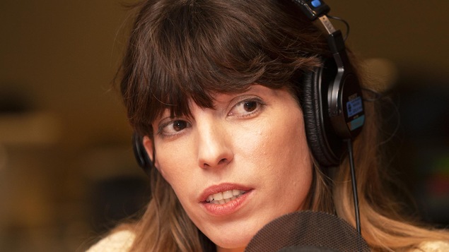 Une femme parle devant un micro.