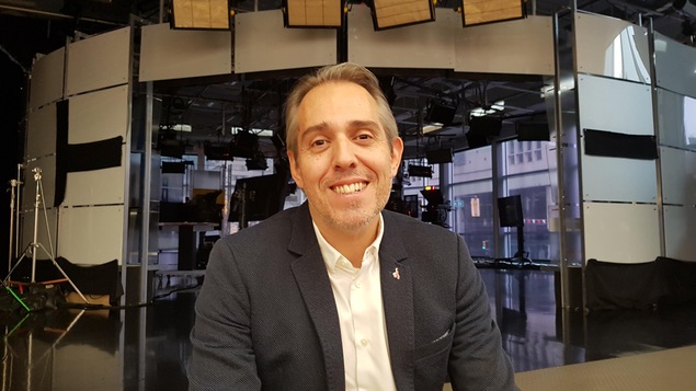 Damien Hubert est assis dans les marches devant le studio télé de CBC/Radio-Canada