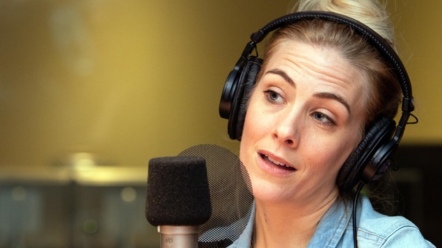 La chroniqueuse culturelle Émilie Perreault parle dans un micro.