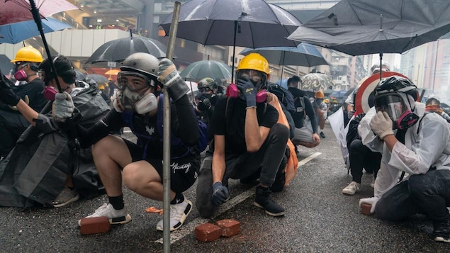 Des manifestants accroupis dans la rue.