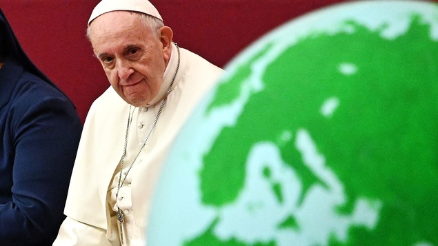Le pape François regarde un globe terrestre.