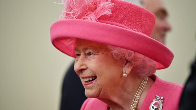 La reine Élisabeth II, souriante, habillée tout en rose.