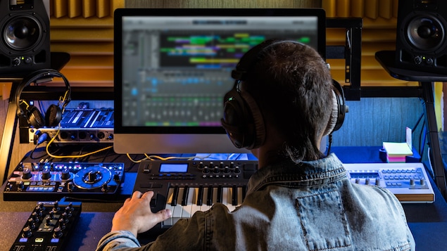 Un technicien de dos dans un studio d'enregistrement.