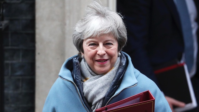 Theresa May portant un manteau d'hiver, à sa sortie de Downing Street à Londres.