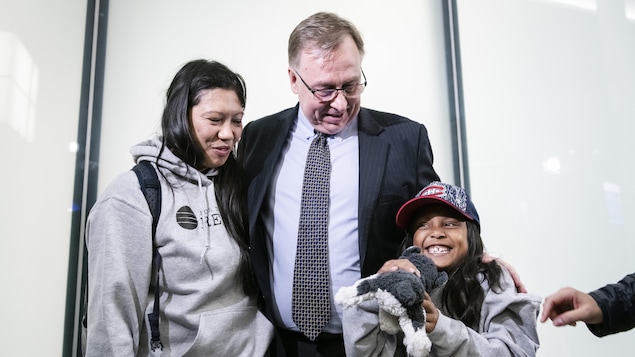 L'avocat Robert Tibbo avec à sa gauche Vanessa Rodel et à sa droite la jeune Keana, qui tient une peluche husky dans ses mains.