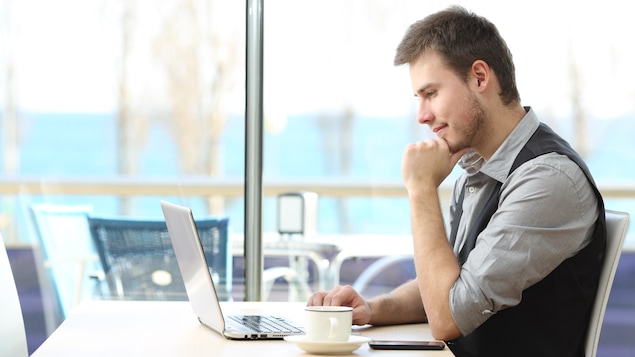 Un homme utilise son ordinateur