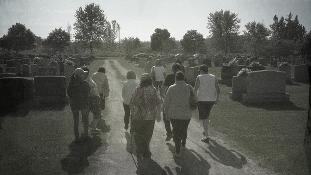 Anne Panasuk en compagnie d'Atimateks de Manawan, de dos, au cimetière de Joliette.