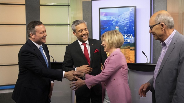Jason Kenney serre la main de Rachel Notley. Les quatre chefs sont souriant.