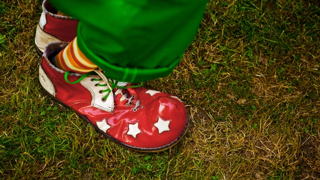 Une chaussure de clown, rouge avec des étoiles.