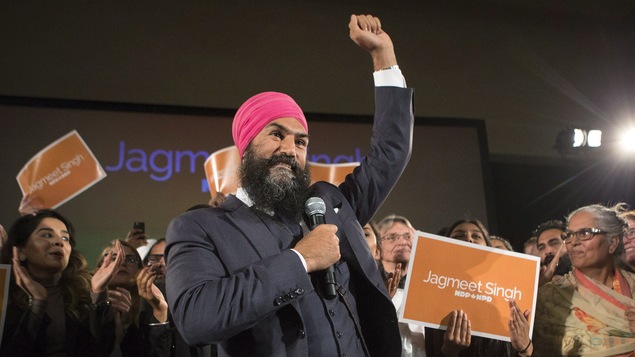 Jagmeet Singh lève le bras en signe de victoire en compagnie de ses partisans.