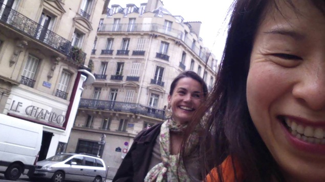 Kim Thúy se prend en photo devant les balcons de Paris.
