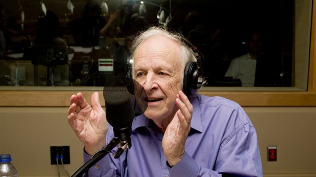 Le comédien Marcel Sabourin chuchote le passage d'un livre à l'oreille des auditeurs.