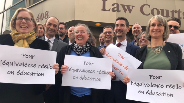 De gauche à droite Suzana Straus, Marie-Pierre Lavoie et Marie-Andrée Asselin tiennent une affiche avec le message Pour l'équivalence réelle en éducation.