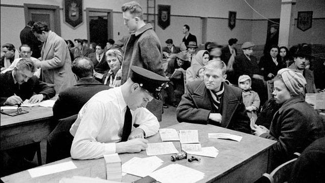 Examens des nouveaux arrivés au pays dans la salle d'examens immigration, Quai 21, Halifax (Nouvelle-Écosse), mars 1952