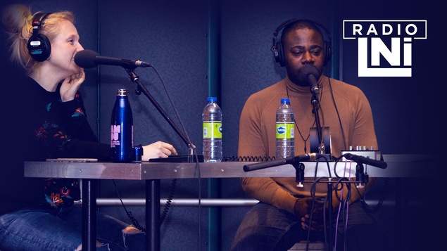 Photo de Marie-Soleil Dion et Richardson Zéphir à une table de radio, derrière des micros.