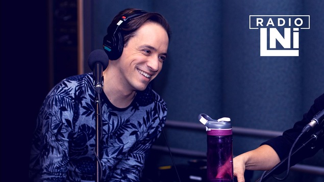 Photo de LeLouis Courchesne, souriant, devant un micro de radio.