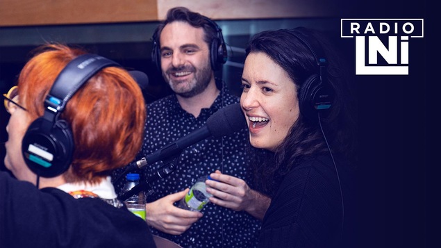 Photo de Chantal Lamarre, de dos, et de Virginie Fortin et Mathieu Lepage, souriants, devant des micros de radio.