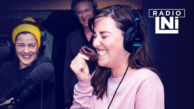 Photo de Sophie Cadieux et Florence Longpré en train de rire, dans un studio de radio, devant des micros et des casques d'écoute sur les oreilles.