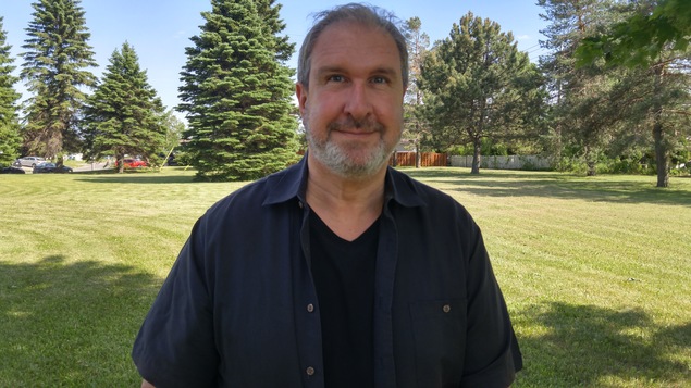 Robert Hakim à l'extérieur sur le terrain de la maison de Radio-Canada à Saguenay.