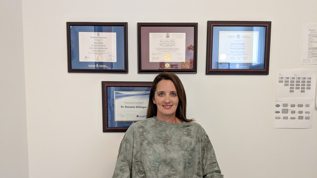 La chercheuse et orthophoniste Roxanne Bélanger assise dans son bureau devant ses diplômes.