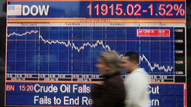 Des passants marchent devant un écran affichant l'indice FTSE, en janvier 2008.