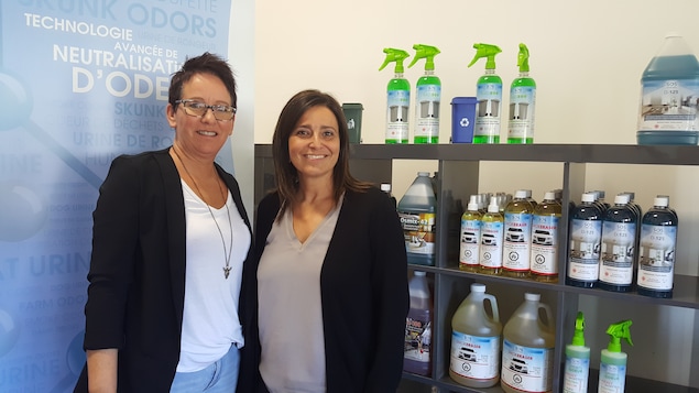 La propriétaire de SOS Odeurs, Josée Samson (à droite) en compagnie de son adjointe administrative Nathalie Grenier. Elles sont devant une étagère remplie de bouteilles de produits neutralisants les odeurs.