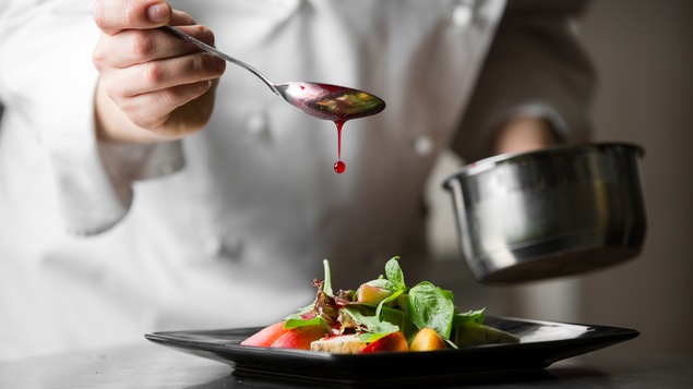 Une cuillerée de sauce est déposée sur un plat