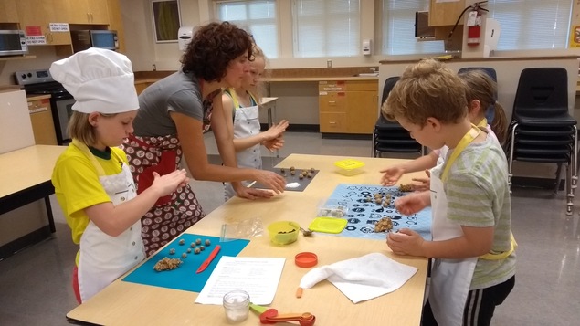 des enfants cuisinent dans une salle de classe