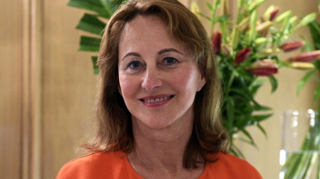 Une femme sourit à la caméra.