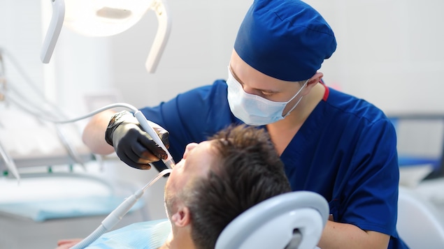 Un dentiste traite un patient.