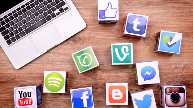 Photo d'un ordinateur et de cubes avec les symboles des réseaux sociaux. Les entreprises privées contrôlent à elles seules les volumes de données nécessaires à la recherche dans le domaine des algorithmes.
