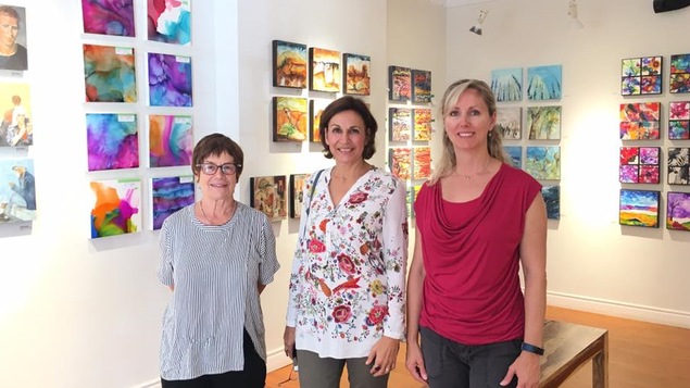 Françoise Cockburn, Emma Aragón & Angèle Blasutti posent devant des oeuvres d'art