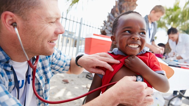 Un médecin soigne un enfant dans un pays du sud.