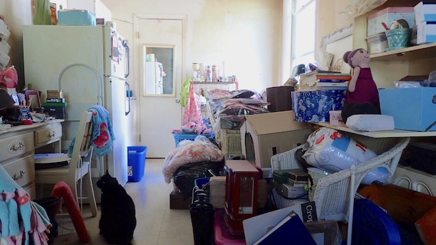 Un petit appartement rempli d'objets divers empilés les uns sur les autres qui couvrent presque tout le plancher.