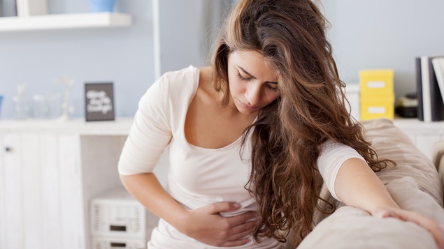 Une femme est incommodée par des douleurs menstruelles.