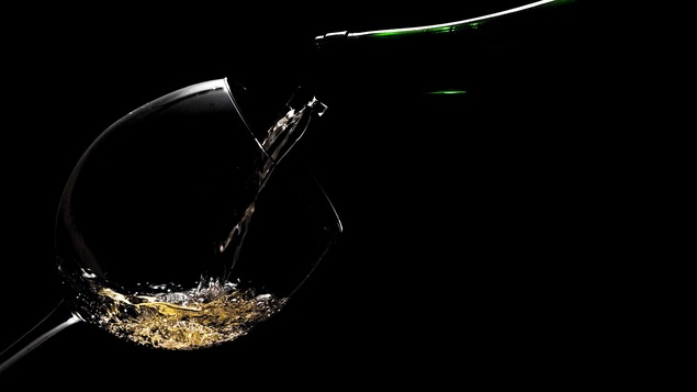 Un verre de vin légèrement éclairé sur fond noir