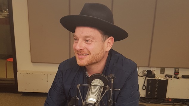 Yann Perreau devant un micro dans le studio de Sur le vif à Ottawa