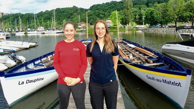 Photo de deux jeunes participantes au Défi international des Jeunes Marins et leurs embarcations, des yoles traditionnelles