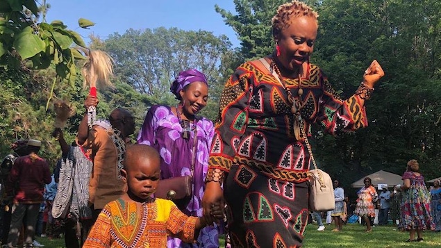 Un enfant et des femmes du peuple Bamiléké dansent.