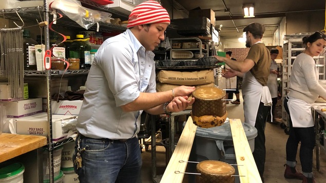 David Mattachioni suspend des panettones à l'envers pour les refroidir.