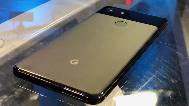 Un téléphone Google Pixel 3 noir sur une table vitrée.