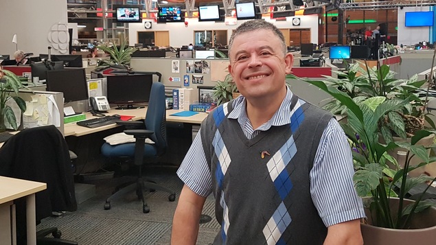 Un homme est photographié dans la salle de nouvelles de Radio-Canada, à Vancouver.