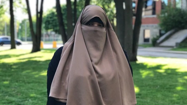 Photo de Zineb Benrochd portant un voile qui laisse voir seulement ses yeux.