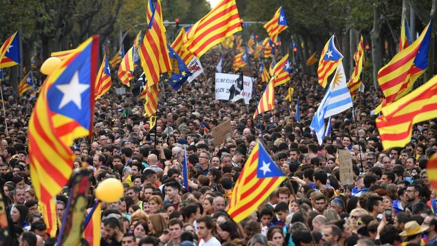 Une foule de manifestants brandissent des drapeaux catalans dans les rues de Barcelone, en Espagne.
